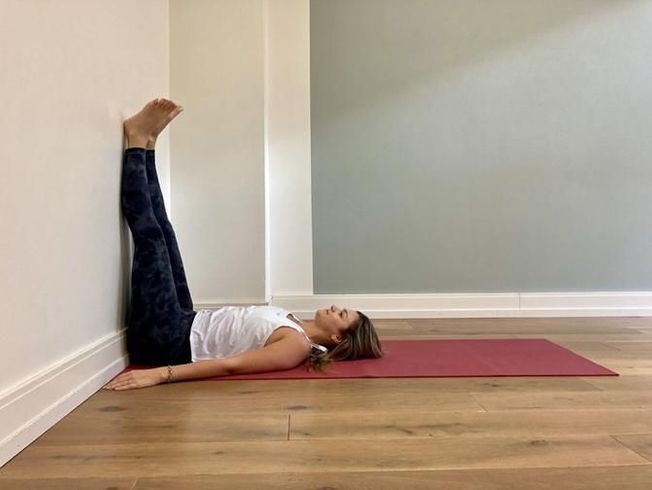 La chandelle contre un mur en yoga.