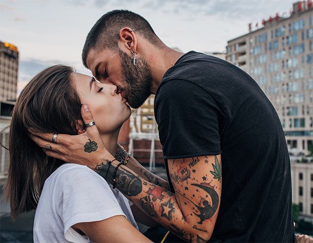 Un homme tatoué qui embrasse une femme.
