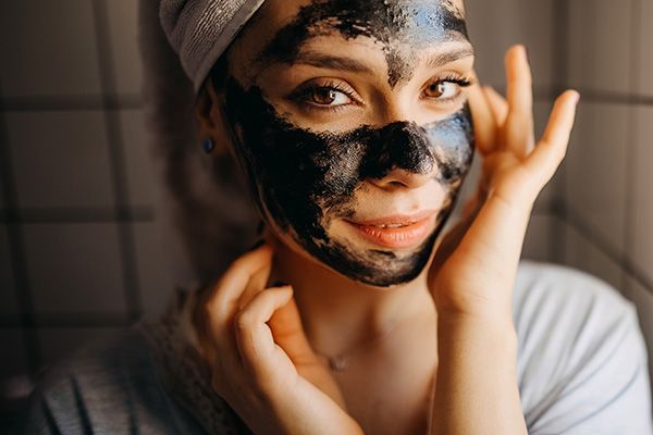 Un masque au charbon sur le visage d'une femme.