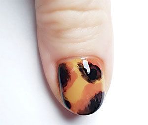 Des écailles de tortue en nail art sur les ongles.