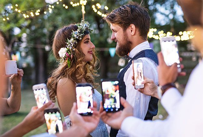 Un couple de marié filmé avec des téléphones portables.